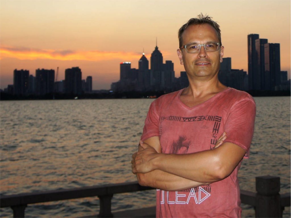 Krzysztof Kowalski against a city skyline at sunset